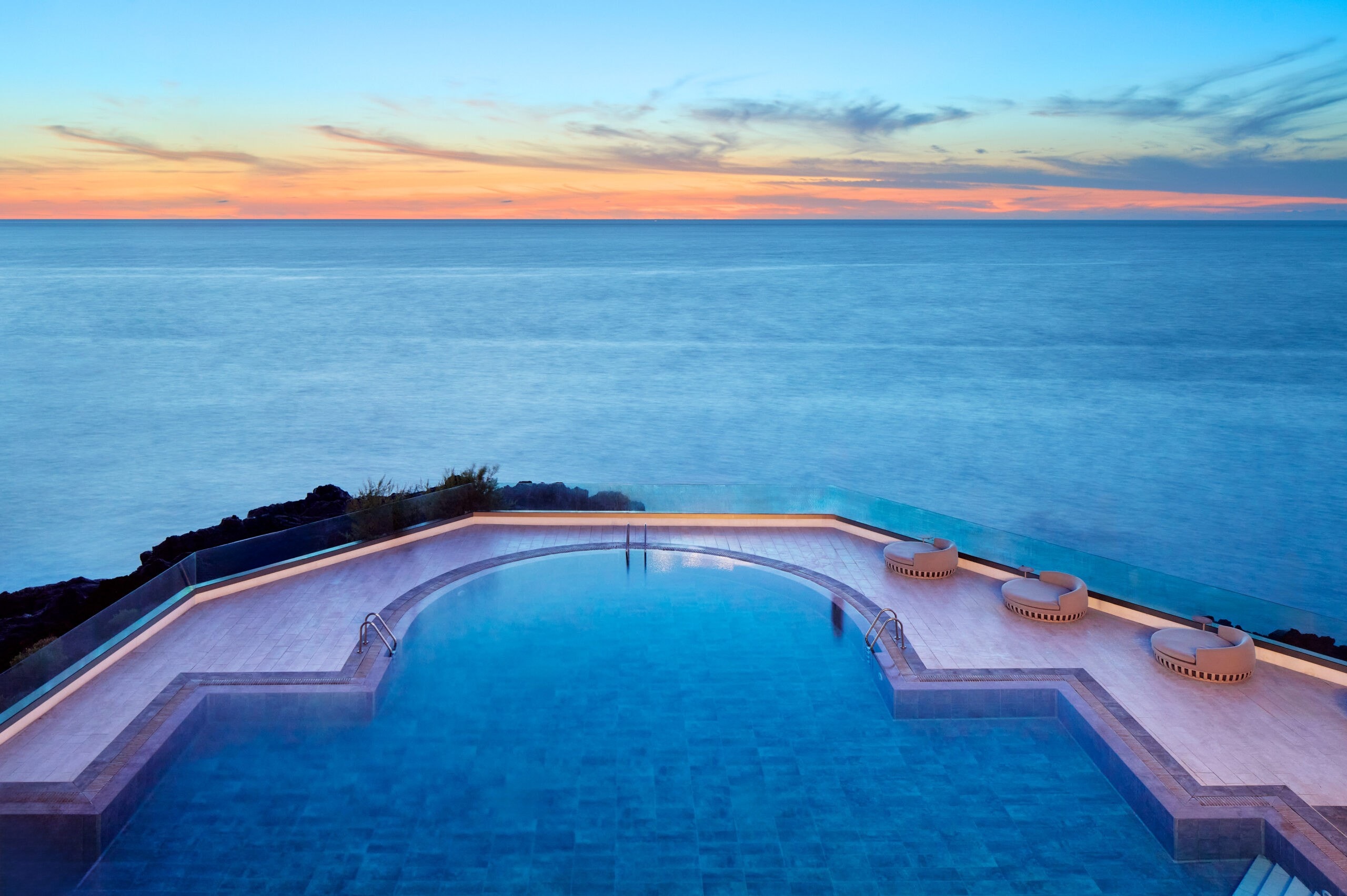 Piscina infinita frente al mar al atardecer